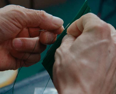 Hand stitching the leather